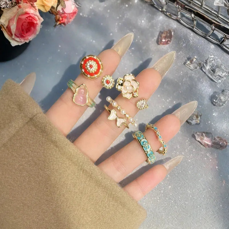 Copper adjustable ring with gourd, flower, and bow design featuring inlaid zircon stones in vintage finish.