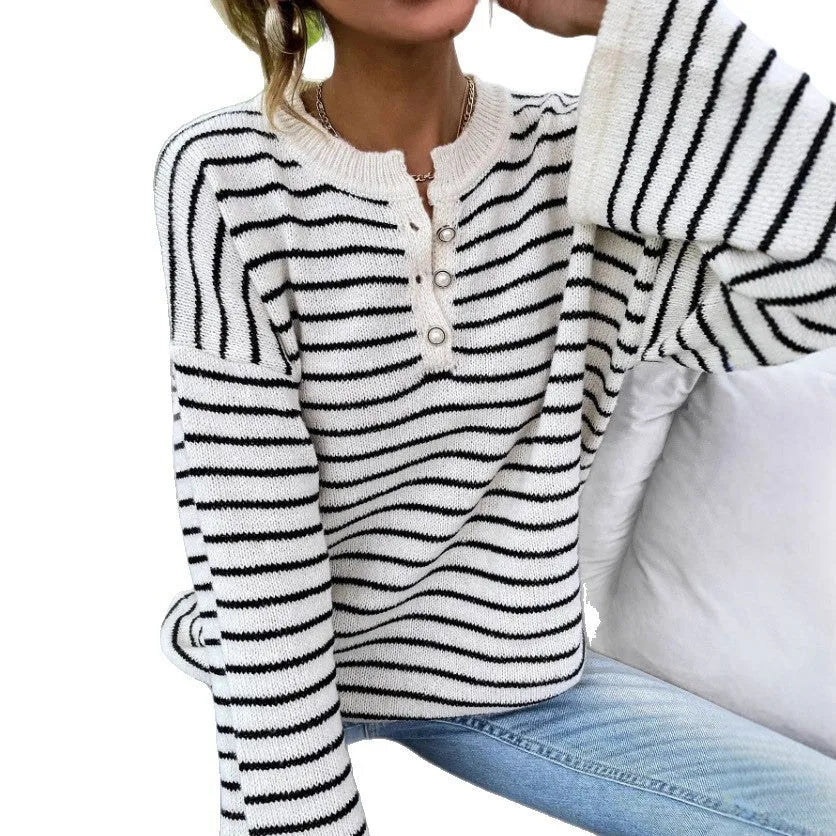 Black striped women's loose long-sleeve top with drop shoulders on a hanger.
