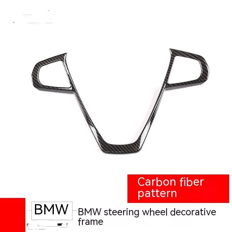 Black carbon fibre pattern button frame decoration for a BMW steering wheel.