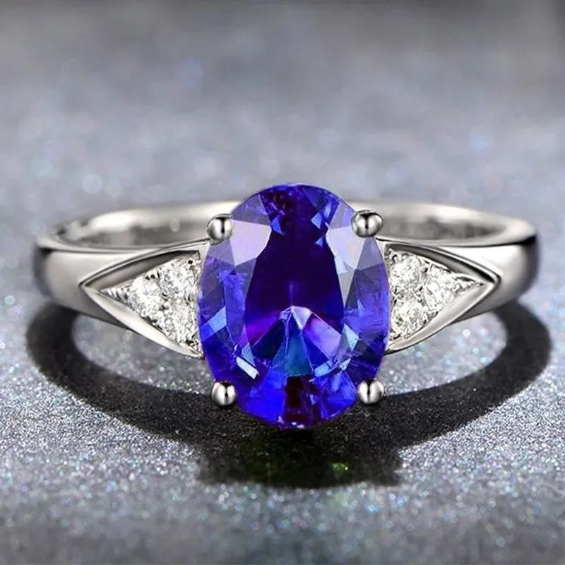 Close-up of a women's court style ring with a red zircon set in a heart-shaped pattern.