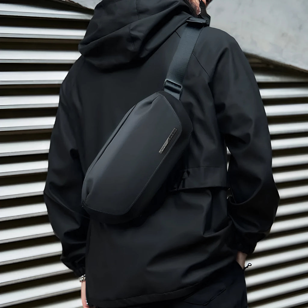 Black men's Oxford cloth messenger bag with cross-body strap on a plain background