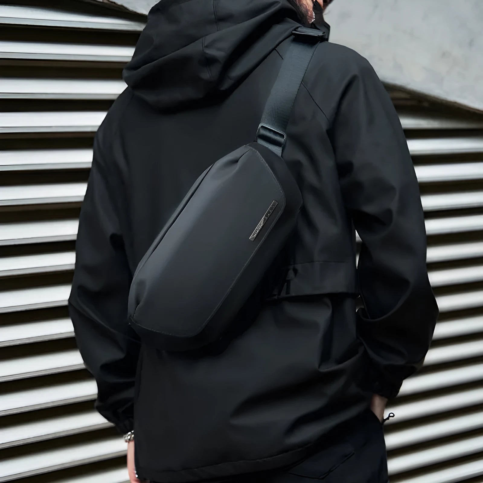Black men's Oxford cloth messenger bag with cross-body strap on a plain background