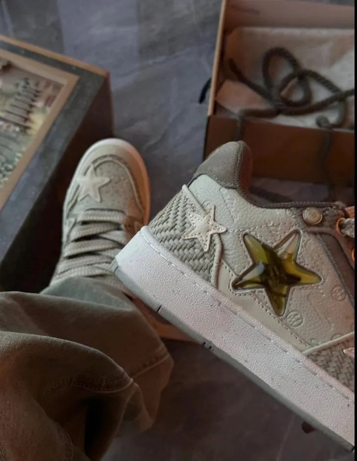 Green low-top casual trainers with star pattern stitching and a white rubber sole.