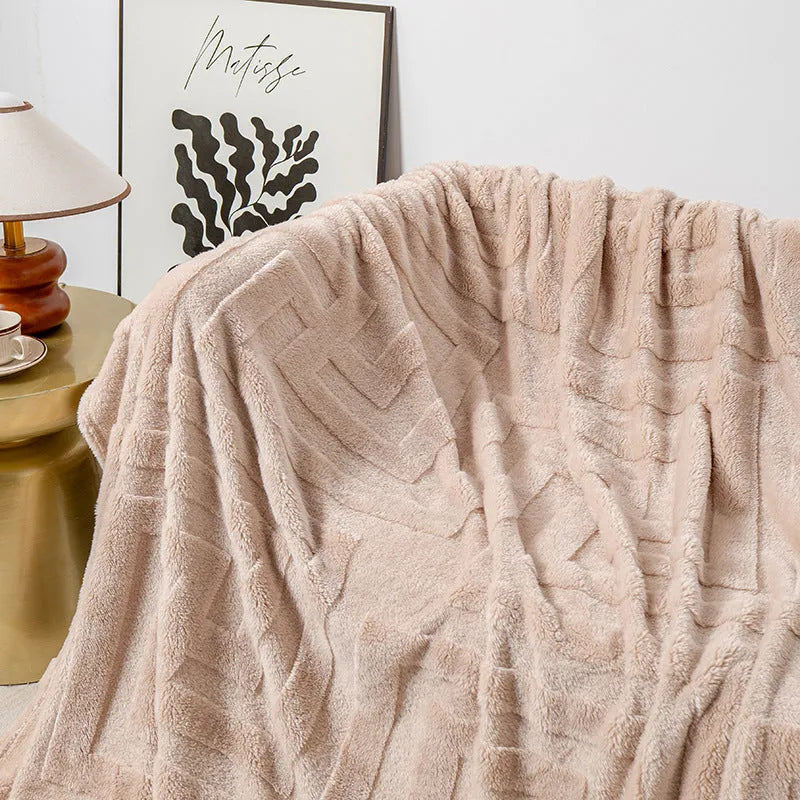 Thick coral fleece sofa blanket in a choice of colours and sizes draped over a grey sofa