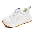 Beige women's low-top leather shoes with cross-strap detail and English muffin heel.