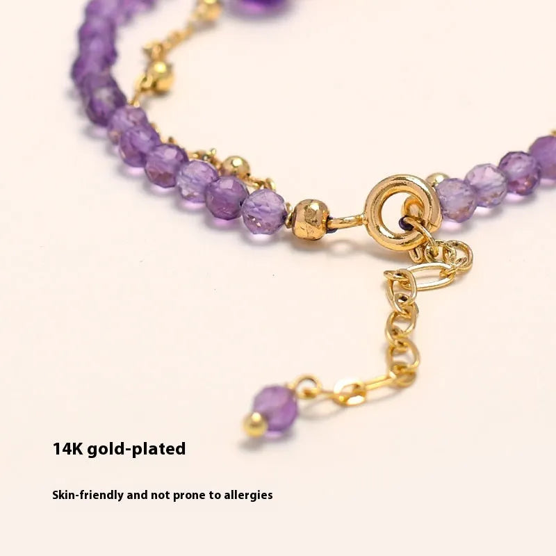 Close-up of a Chinese style women's bracelet with a diamond-shaped amethyst crystal on an electroplated chain.