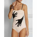 Women's one-piece bikini swimsuit with a light gauze skirt attached, shown on a model.