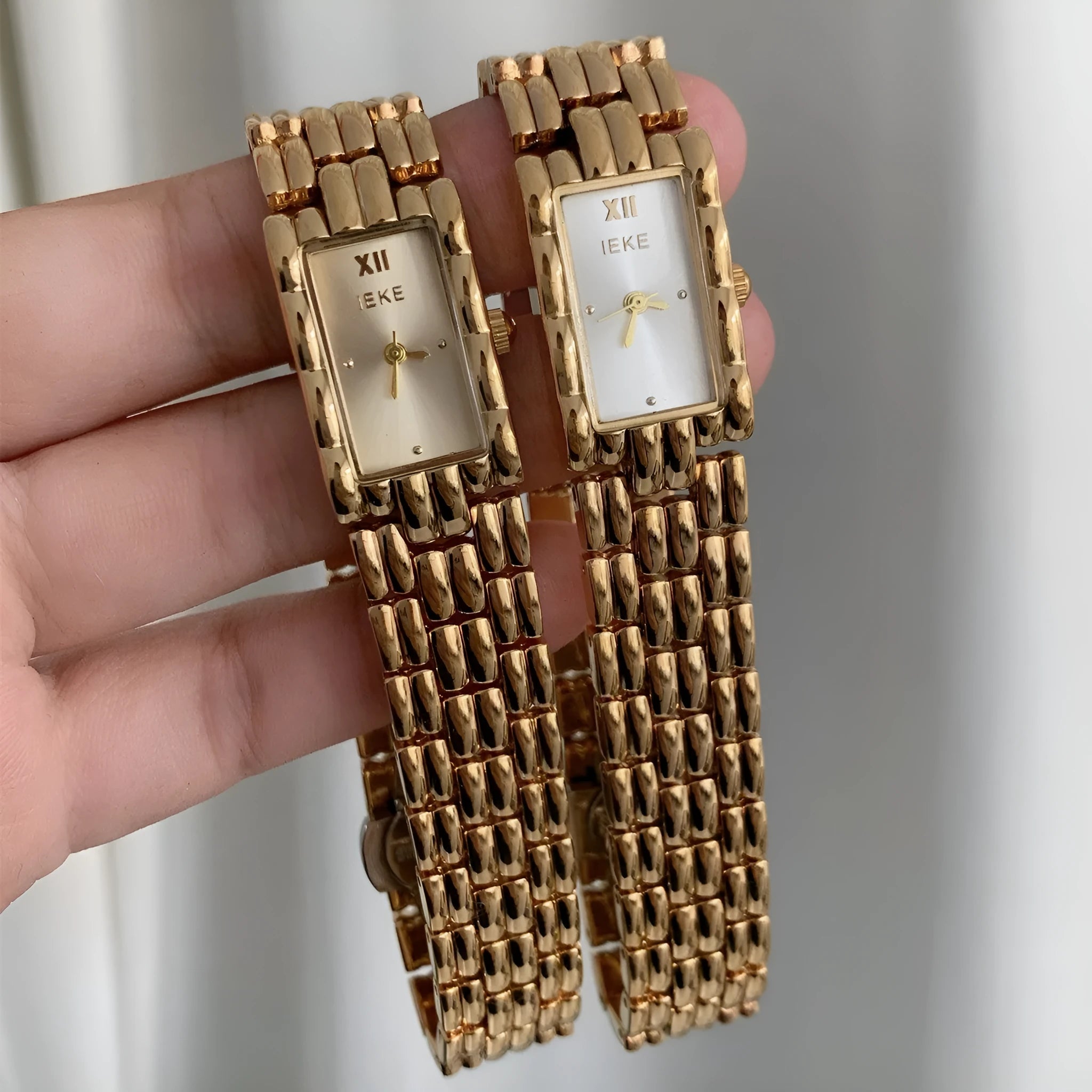 Women's bracelet-style watch with 15mm dial, silver stripe strap, and butterfly clasp