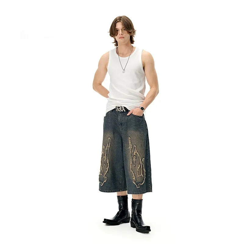 Men's black denim shorts with flame embroidery patch detail, cropped length and straight leg street style