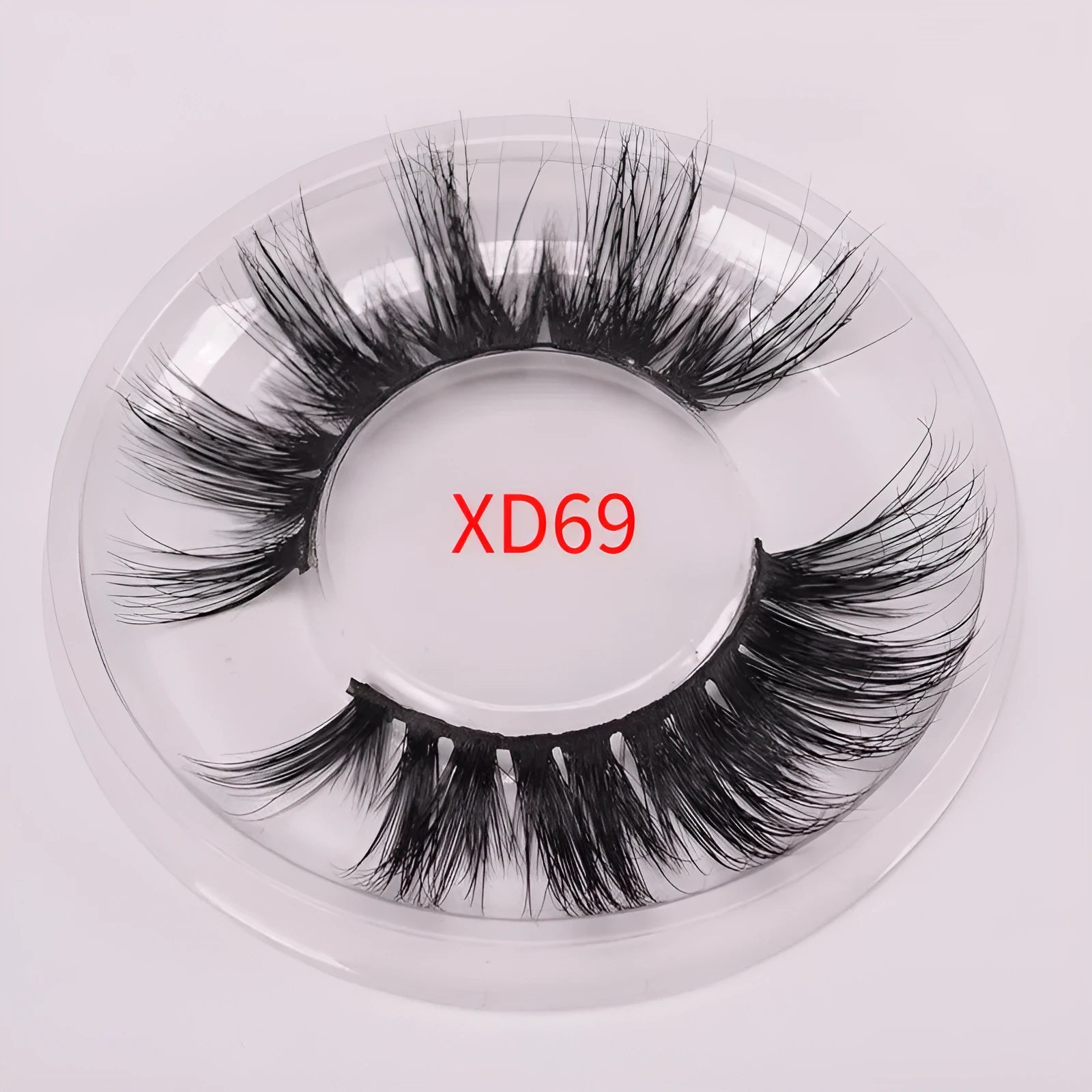 A pair of handmade 5D false eyelashes made from mink hair, shown with a double-headed brush and a hair cap.