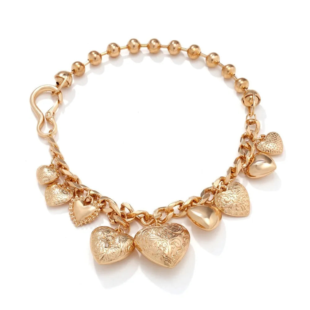Carved heart-shaped alloy pendant on a metal chain necklace in gold colour.