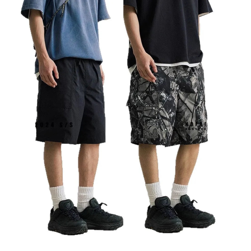 Man's loose straight-leg denim shorts in black on a hanger, showing mid-rise waist and zip fly.