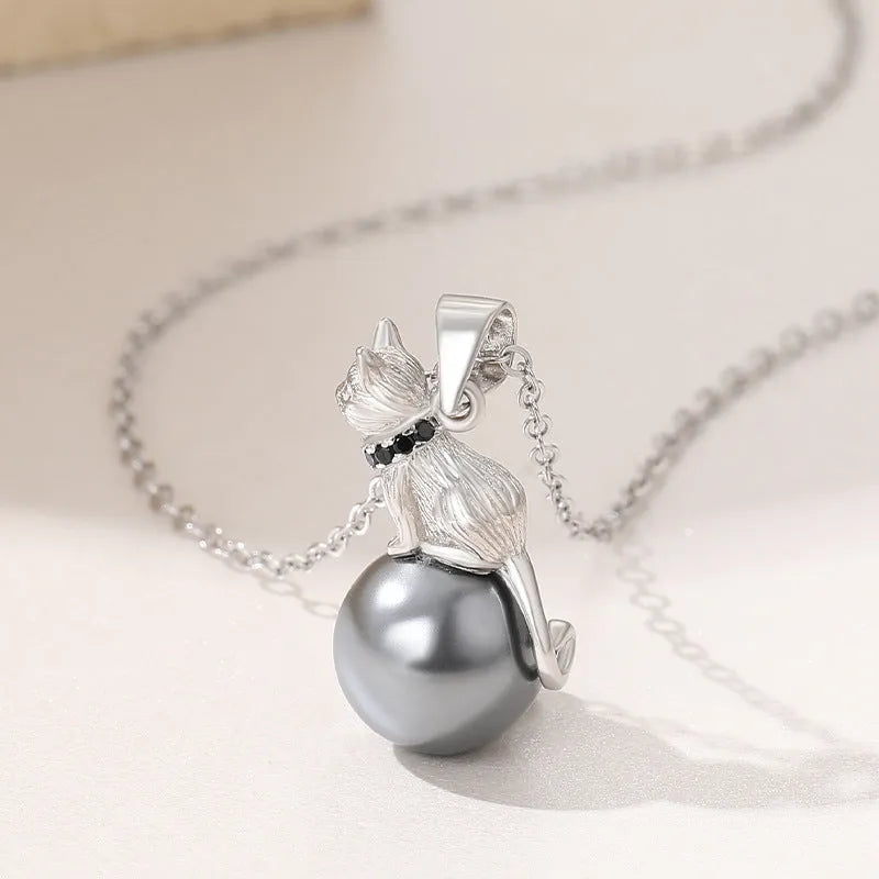Close-up of a sterling silver cat silhouette pendant on a delicate silver chain.