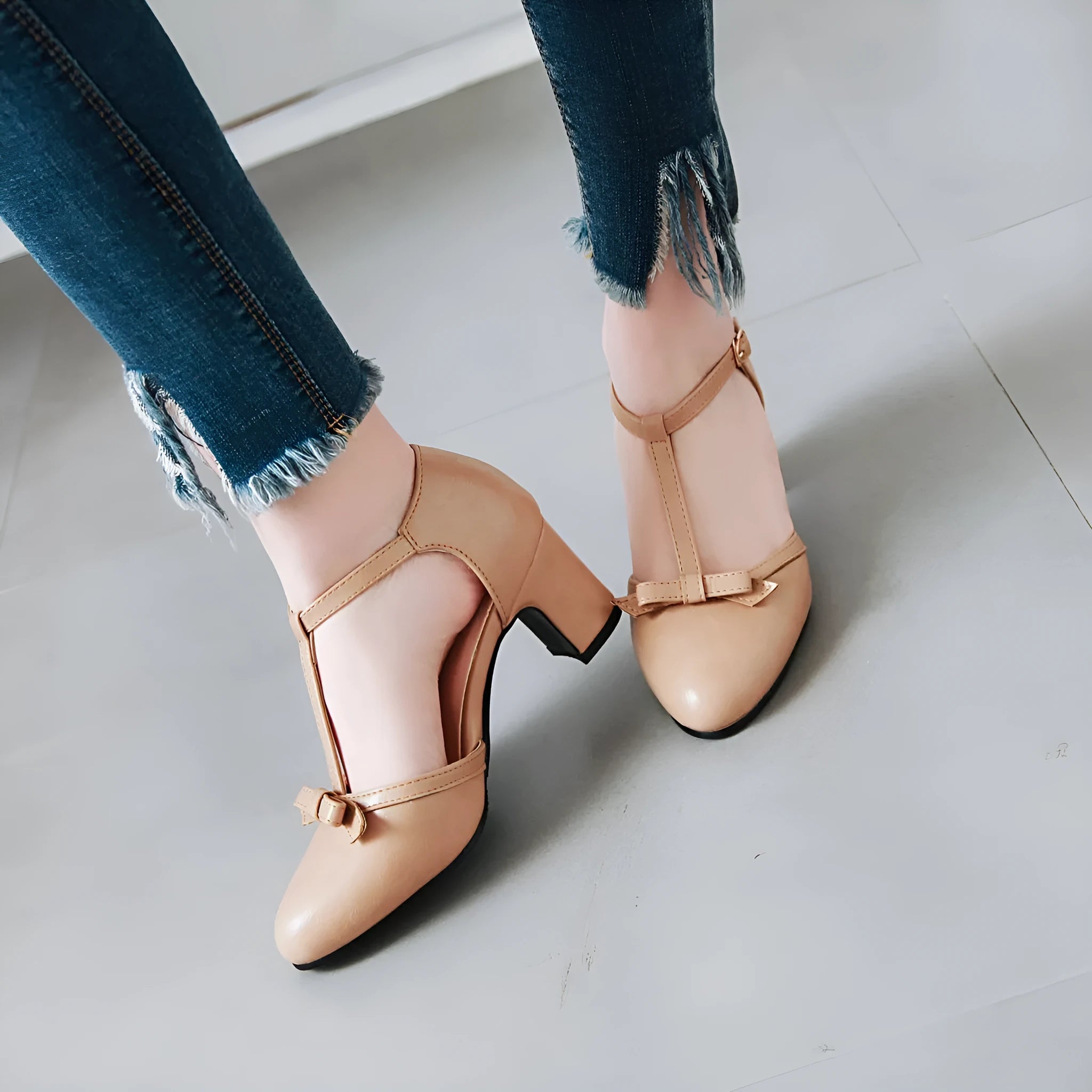 Women's apricot coloured chunky heel sandals with a bow tie and adjustable buckle strap.