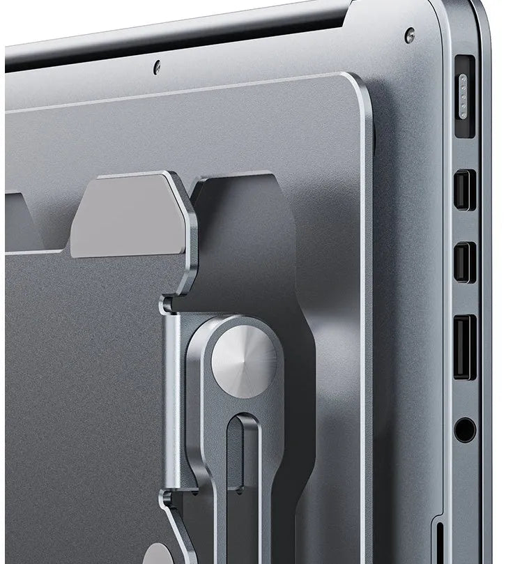 Grey aluminium folding laptop stand holding a silver laptop at an angle on a wooden desk.