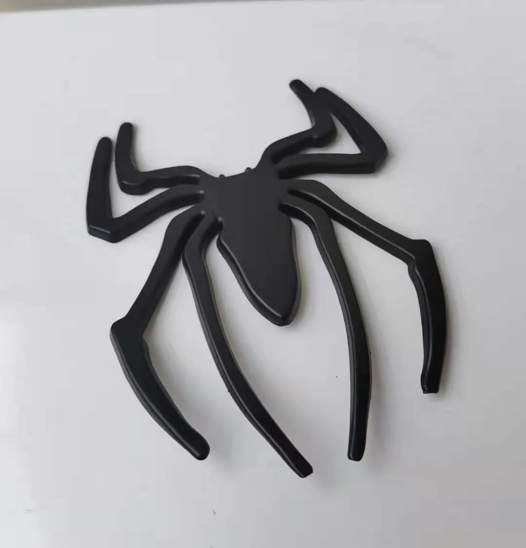 Three-dimensional metal spider bumper sticker in zinc alloy, shown in gold colour.