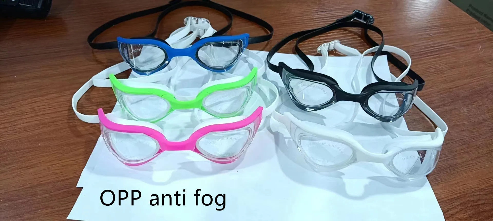 Racing style swimming goggles with mirror lenses and adjustable nose bridge on a blue background.
