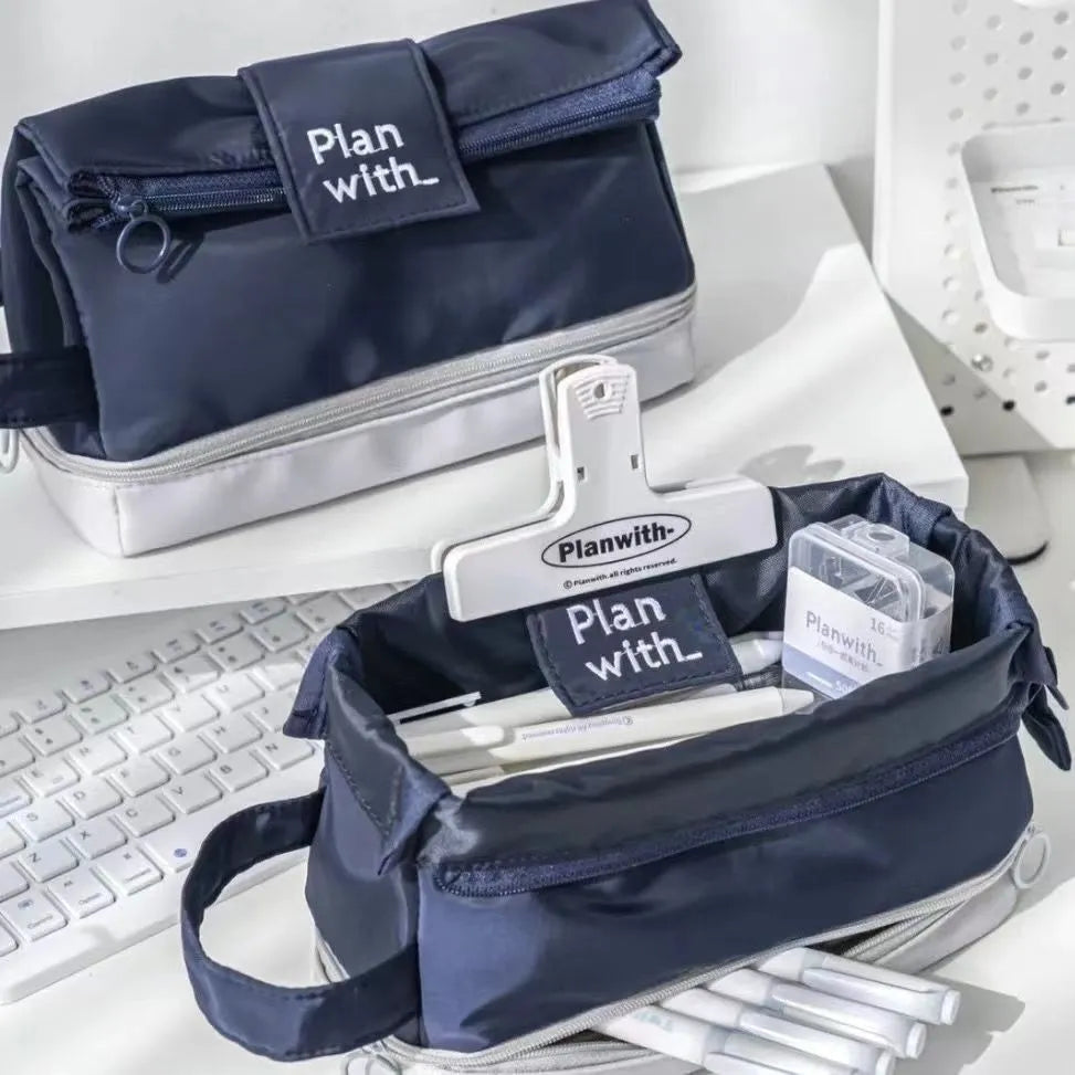 Dark blue folding double-layer polyester pencil case for pens and stationery, shown open to reveal two compartments.