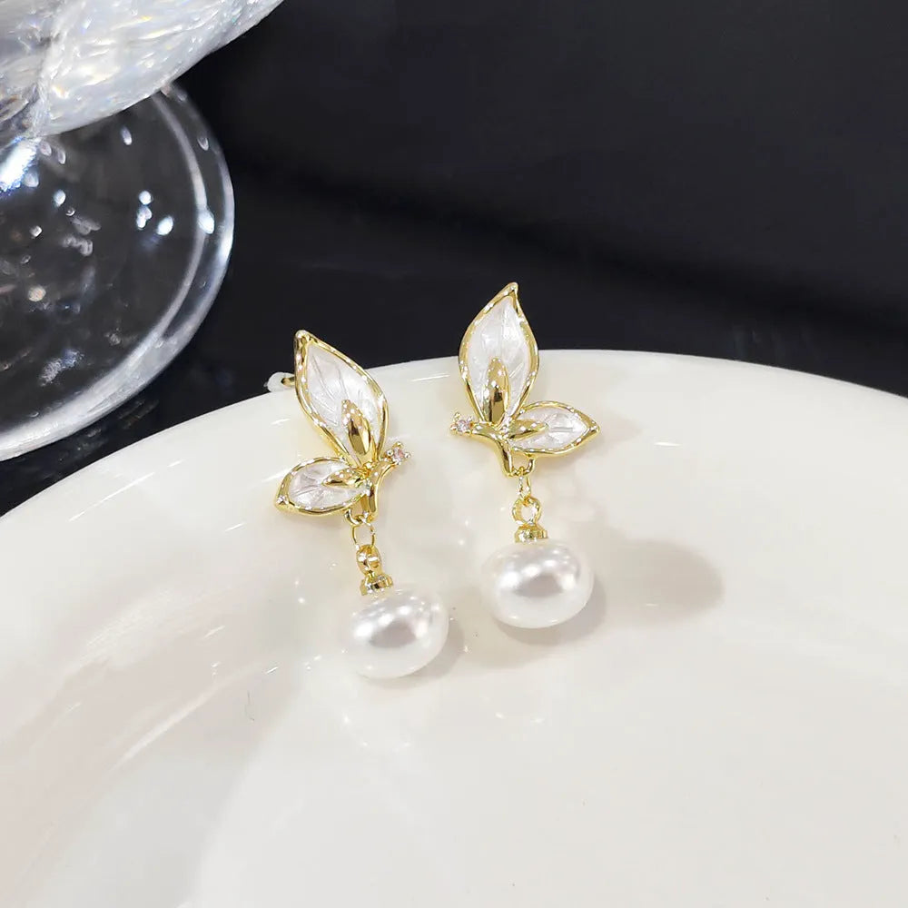 Close-up of zircon painted butterfly stud earrings on copper with electroplated finish