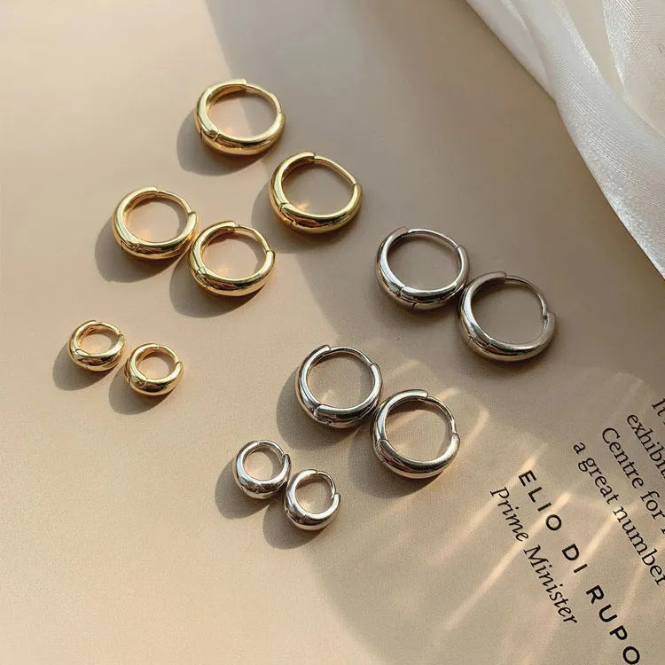 Women's minimalist copper water drop earrings in gold or silver, shown in large, medium, and small sizes.