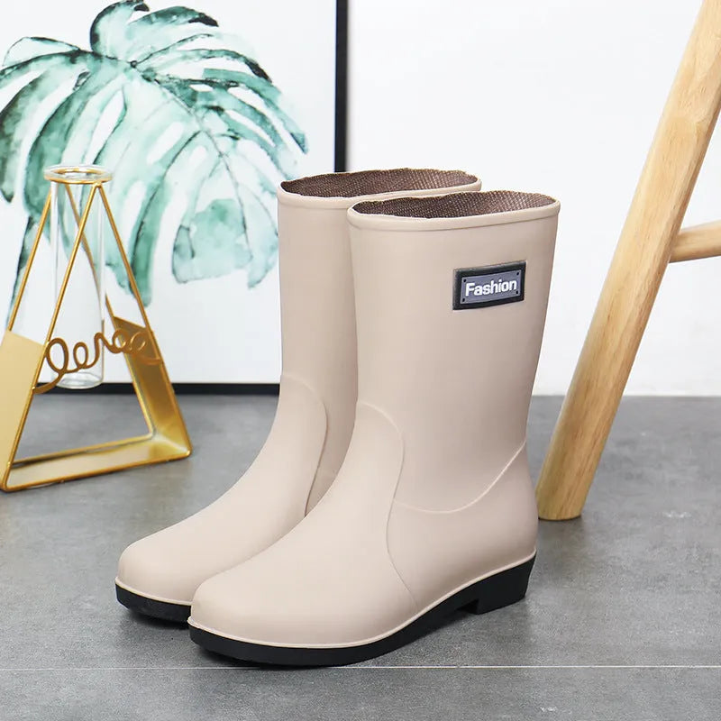 Women's mid-calf PVC rain boot in black with a low heel on a white background.