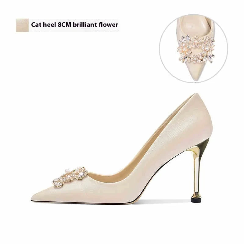 Rhinestone decorated pointed-toe bridal high heels on a white background.