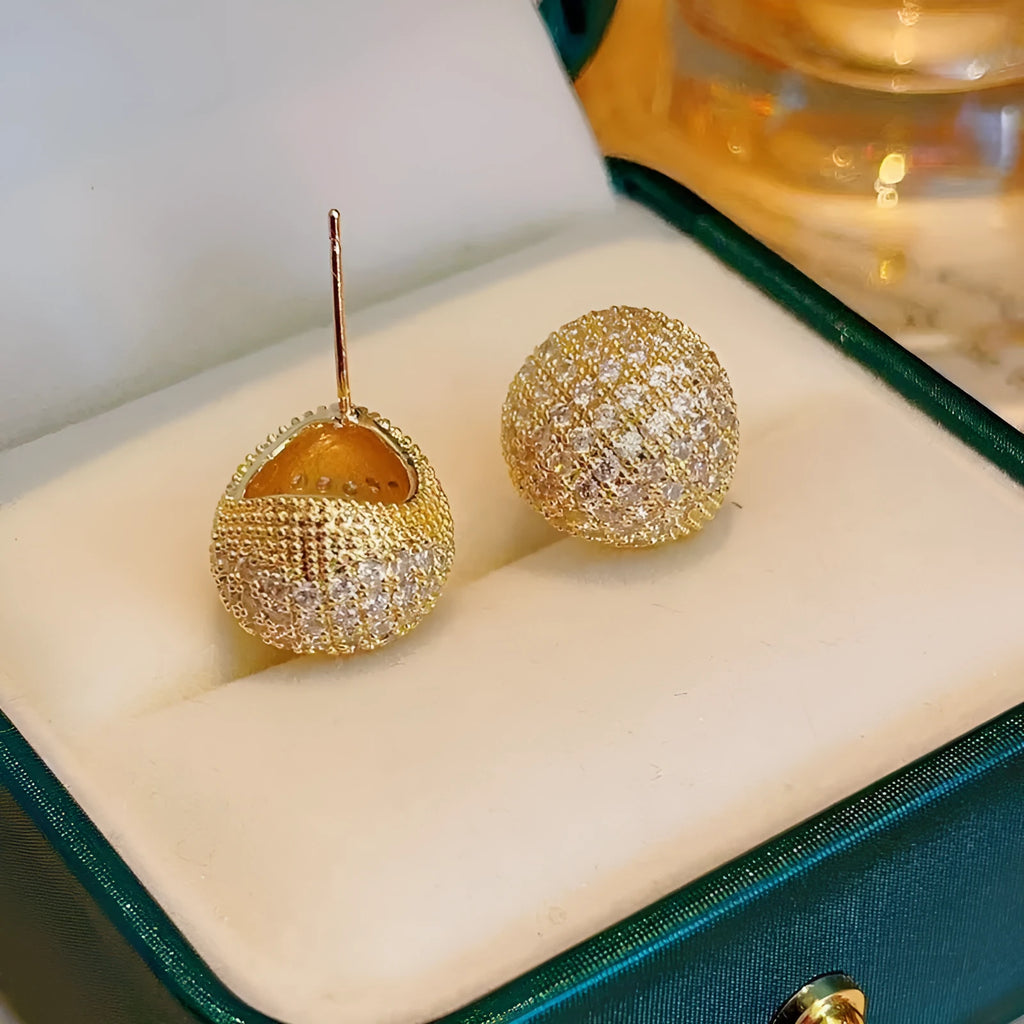 Gold and white geometric drop earrings with sparkling diamond-cut bean spheres.