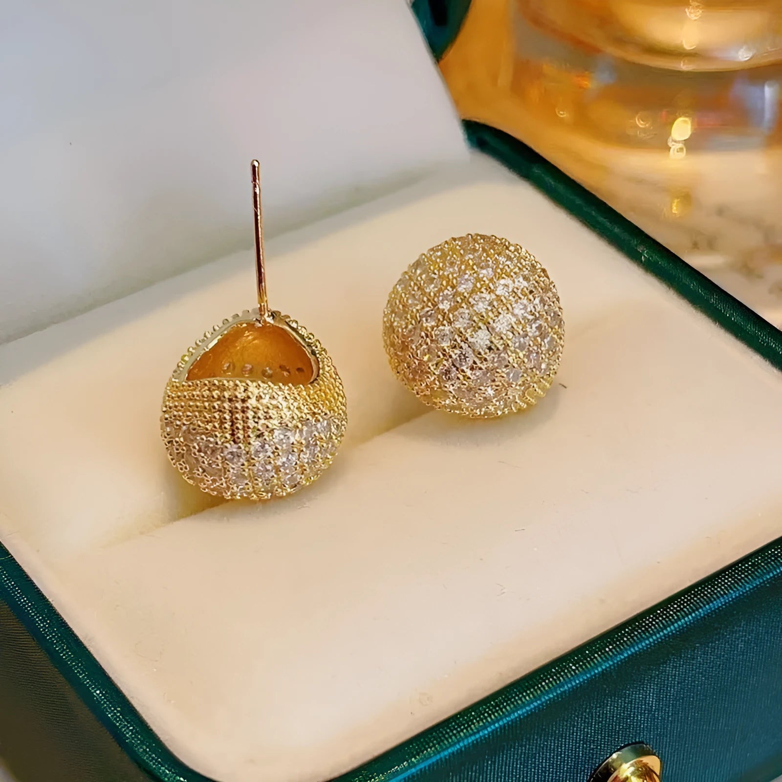 Gold and white geometric drop earrings with sparkling diamond-cut bean spheres.