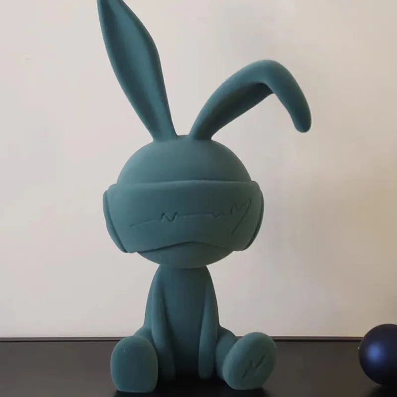 Small resin rabbit table ornament with a suede blindfold, shown in green, blue, and red colour options.