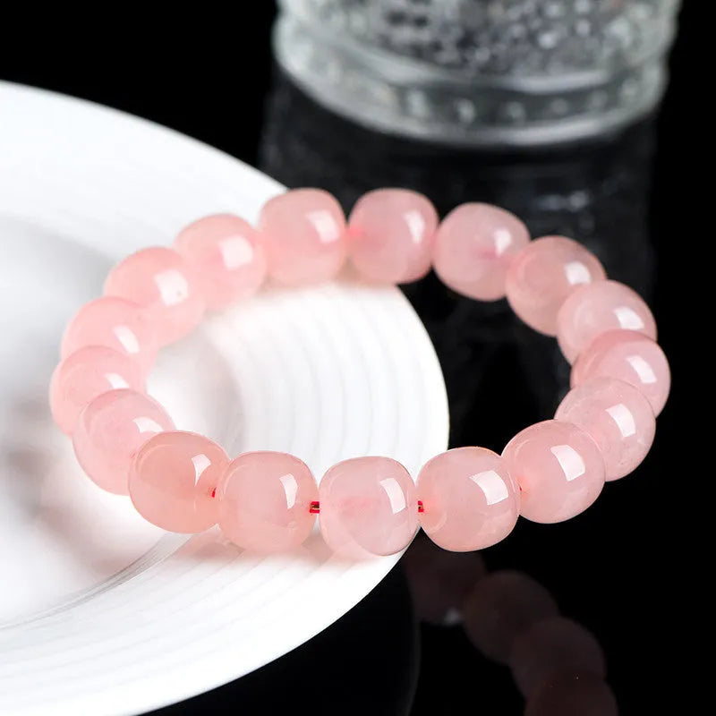 Natural pink crystal barrel bead bracelet with 8x10mm geometric beads on wrist