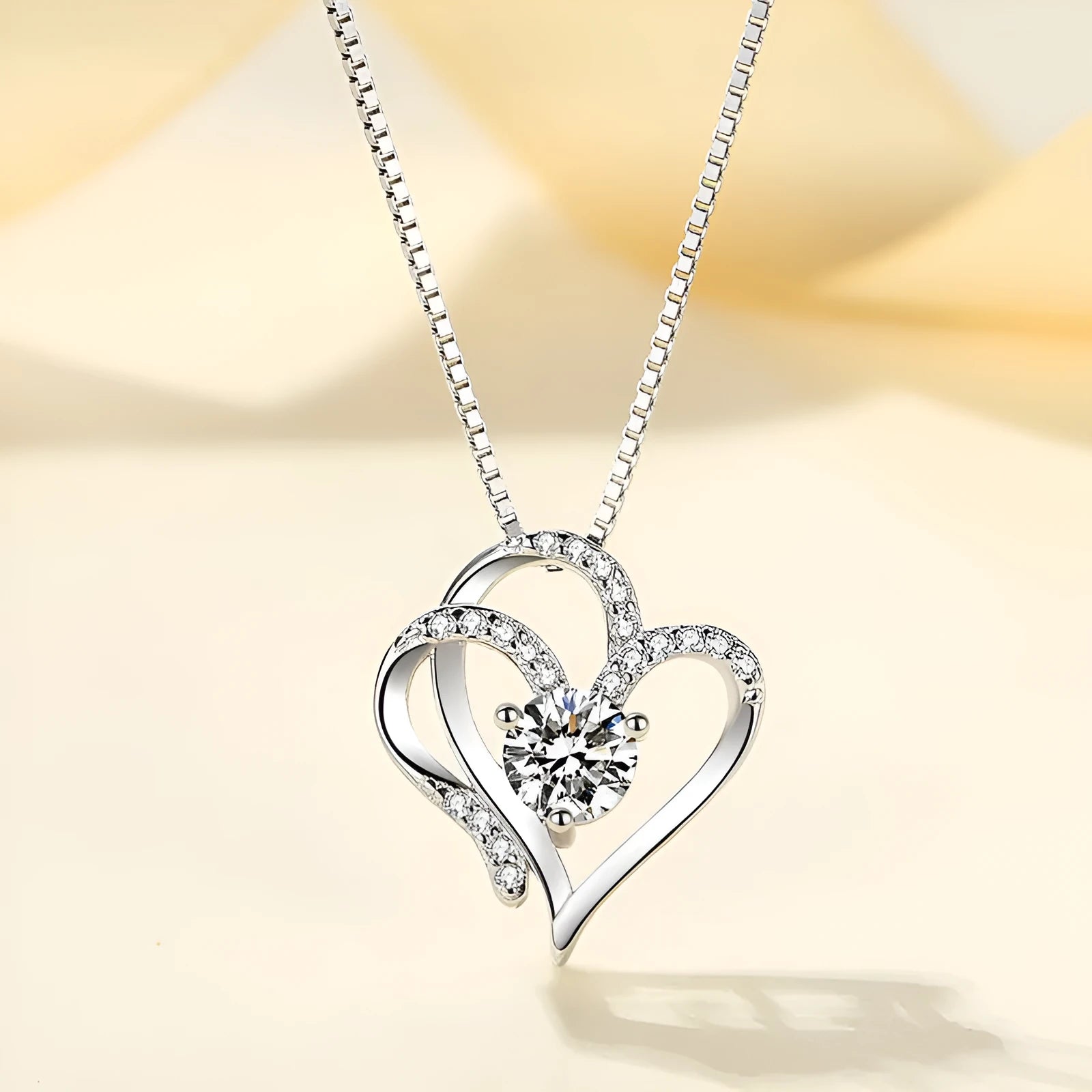 Women's heart-shaped silver necklace shown in rose gold, white gold, and yellow gold plating variations.
