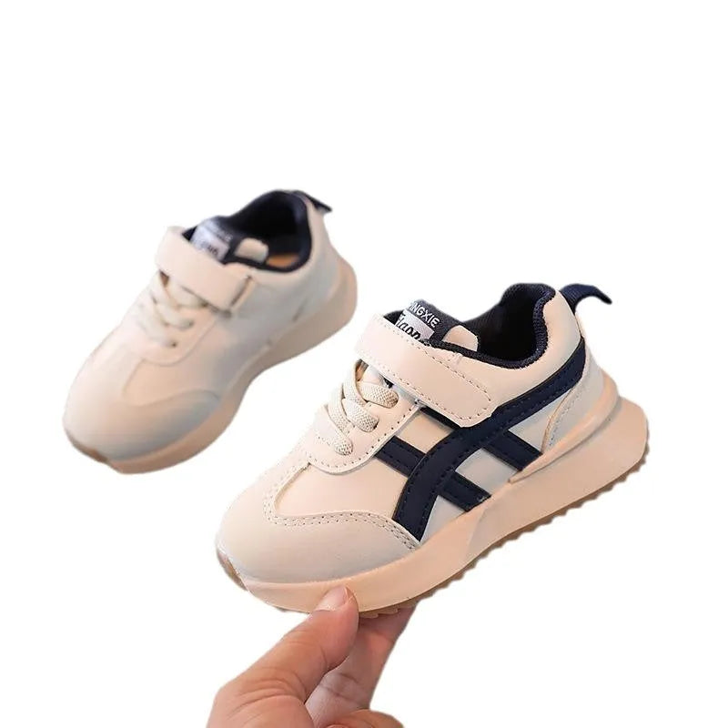 Children's white casual sneaker with Velcro strap on a non-slip rubber sole.