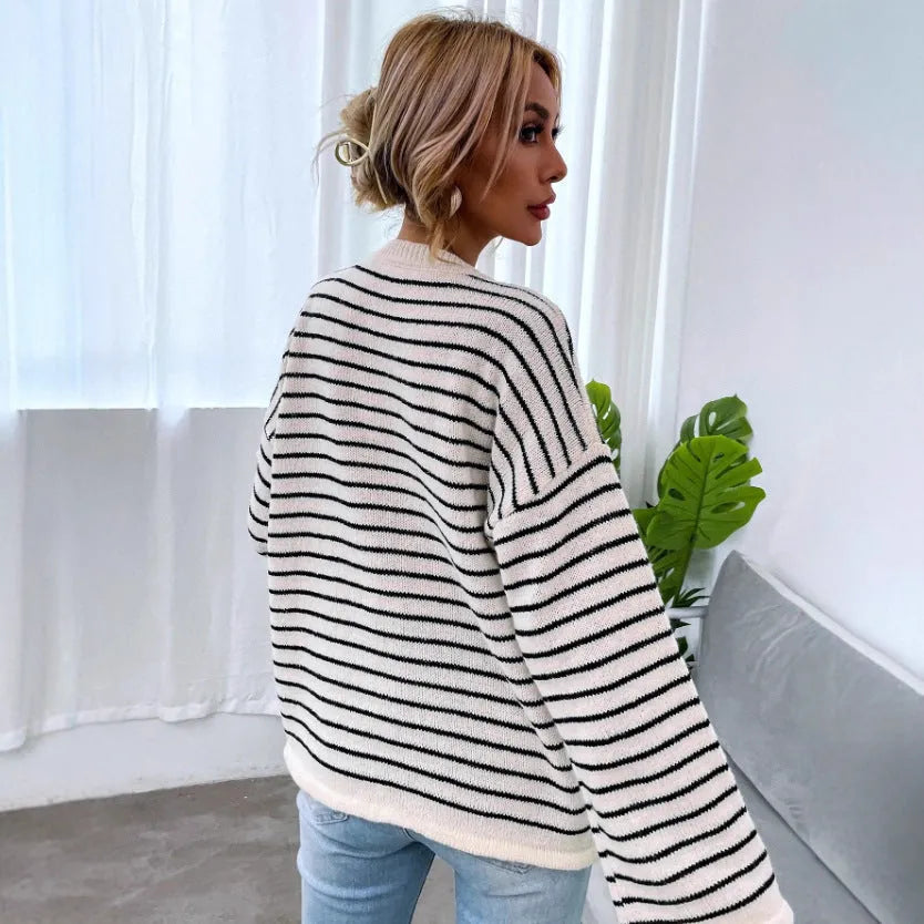 Black striped women's loose long-sleeve top with drop shoulders on a hanger.