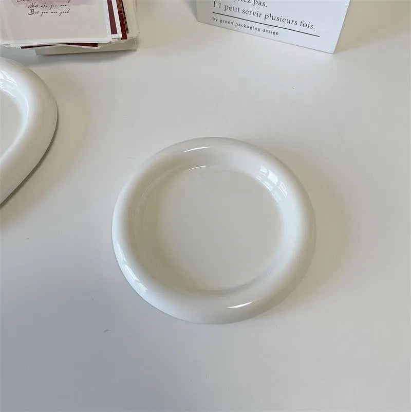 White round ceramic plate with bear doodle design, used as a saucer for a small succulent plant pot.