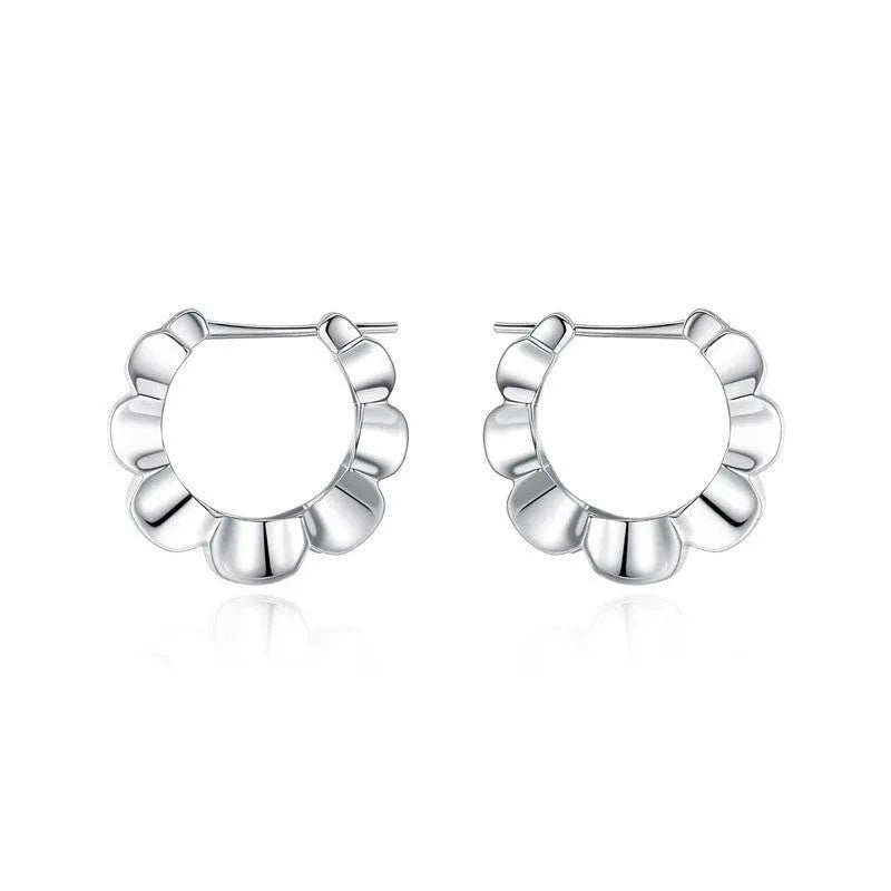 A pair of sterling silver geometric earrings with round details on a simple background.