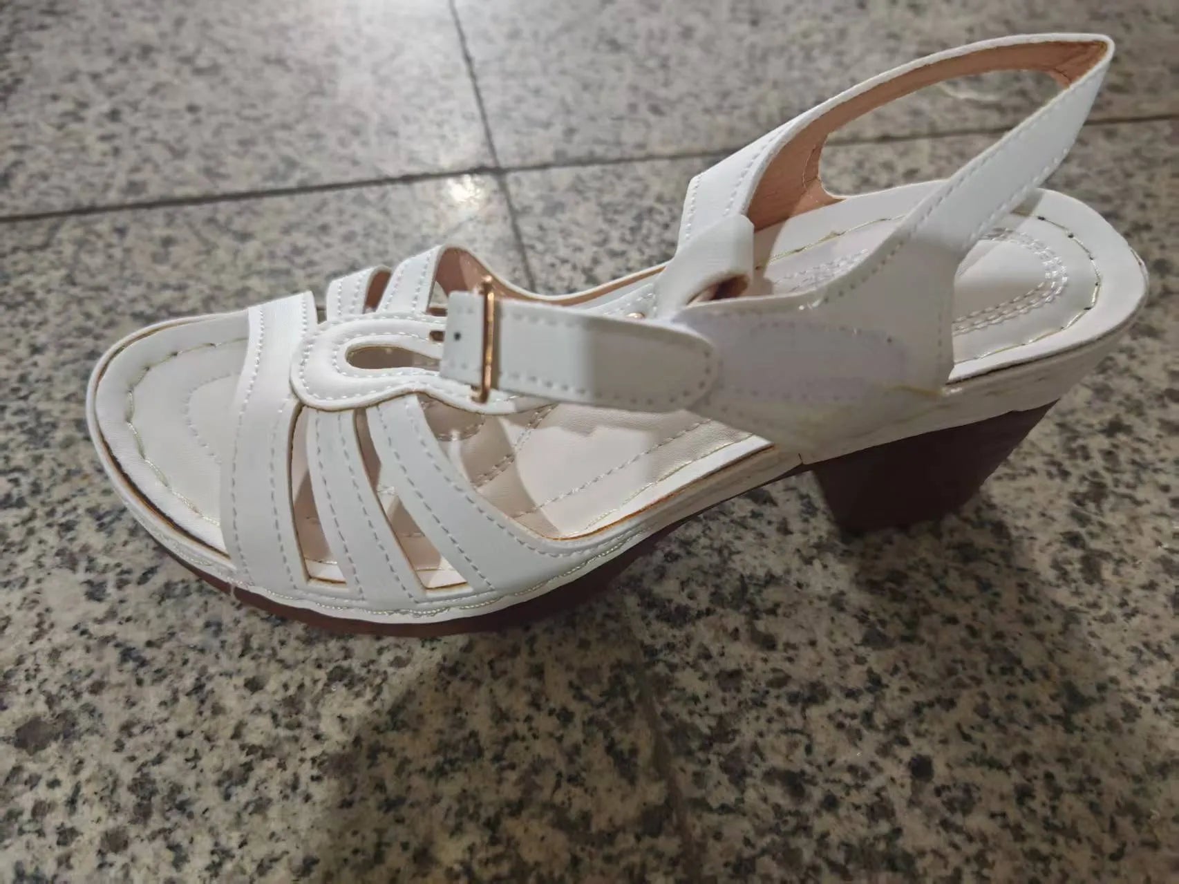 Women's black peep toe wedge sandals with a buckle fastening on a white background.