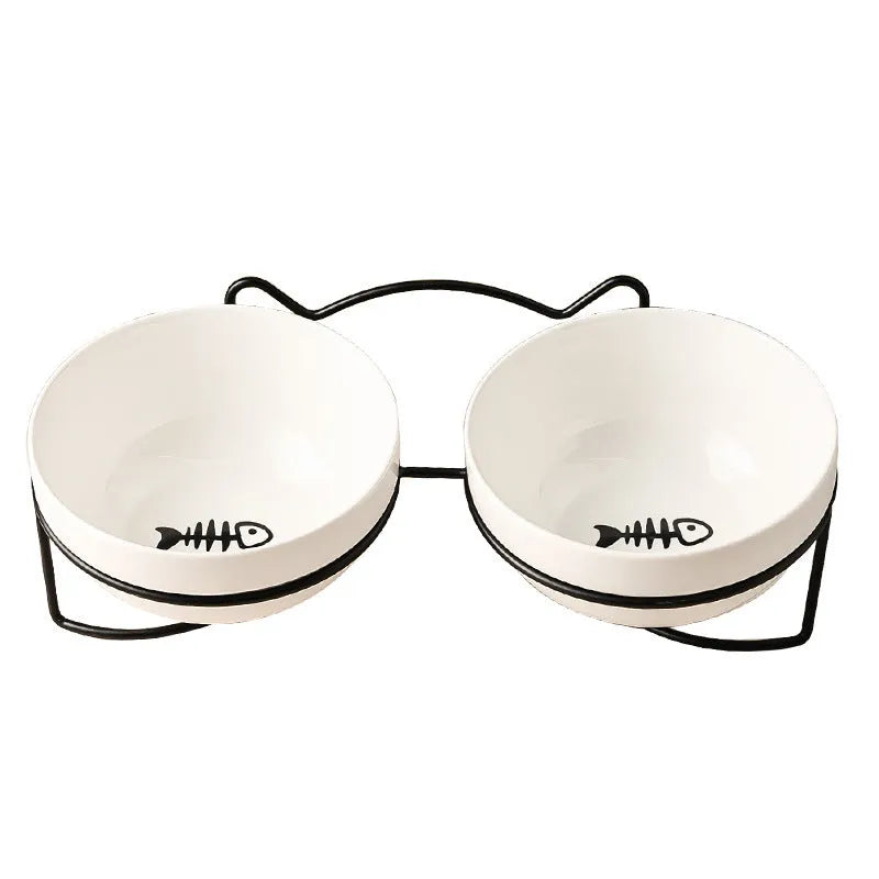 White ceramic cat bowl with decorative pattern sitting in a black iron frame stand.