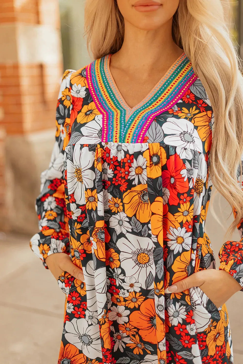 Orange floral print striped lace V-neck long sleeve mini dress on a hanger