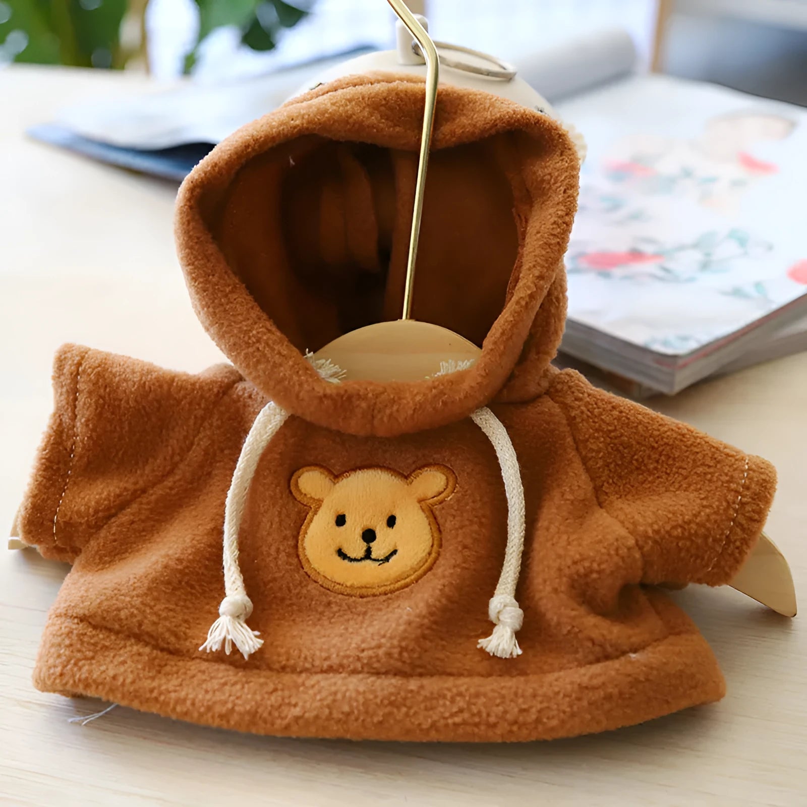 A small dog wearing a blue cloth hoodie sweater from the range of six available colours.