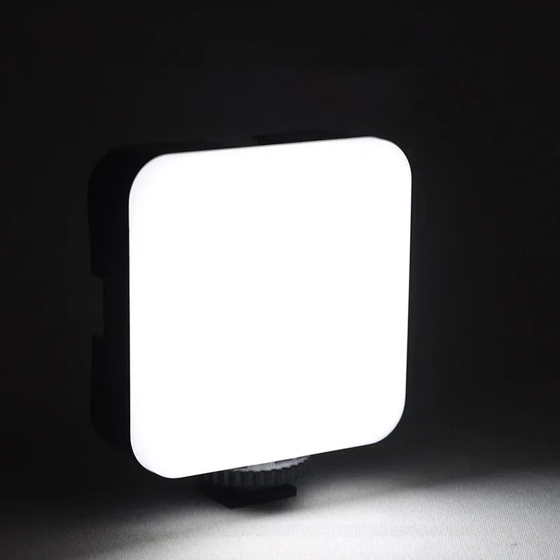 LED mini square universal camera flash on a pocket tripod, showing compact size and rotatable flash head.