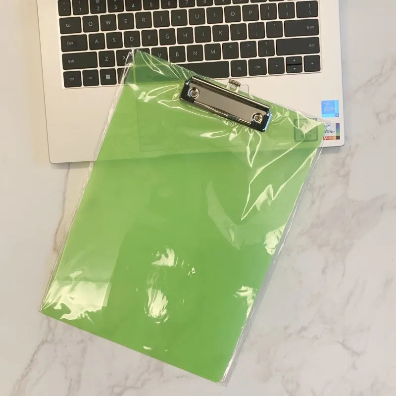 Transparent A4 writing board pad with metal clip holding paper, shown in blue colour variant.