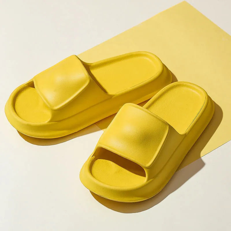 Pair of thick-soled white EVA foam flip-flop slippers on a bathroom floor, showing non-slip tread pattern.