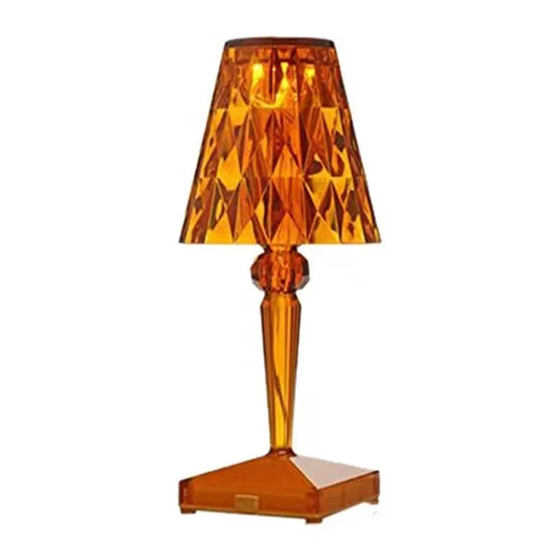 Rose gold portable touch projection night light on a wooden surface.