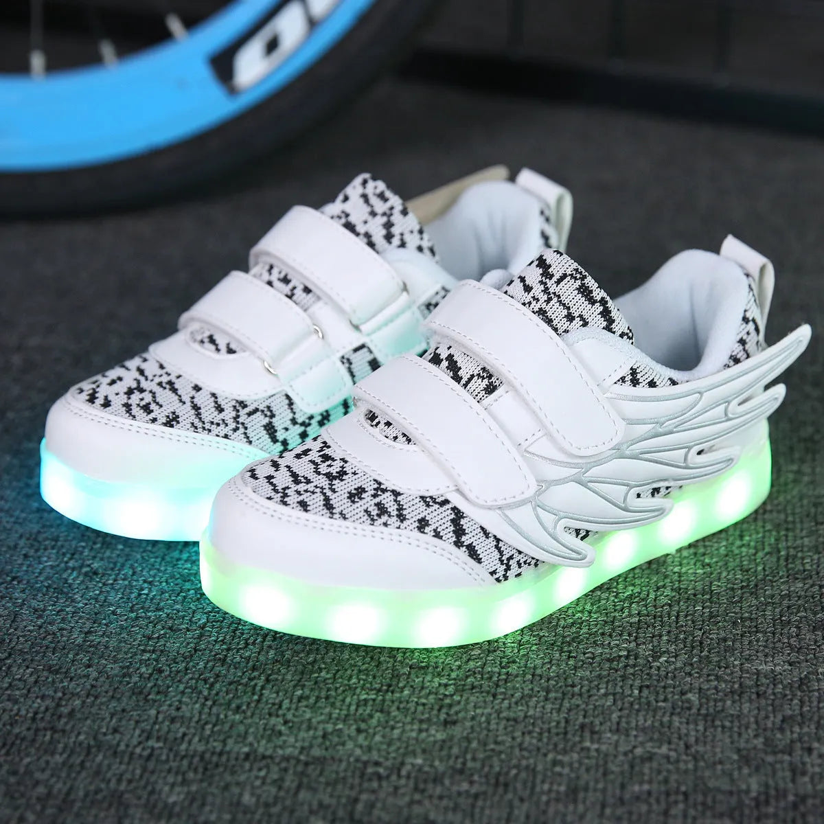 Children's plum red and white LED light-up sneakers with USB charging port visible.