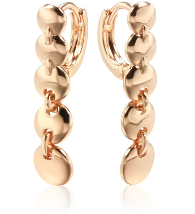A pair of long gold-colour retro earrings with a woven round circle design made from copper.