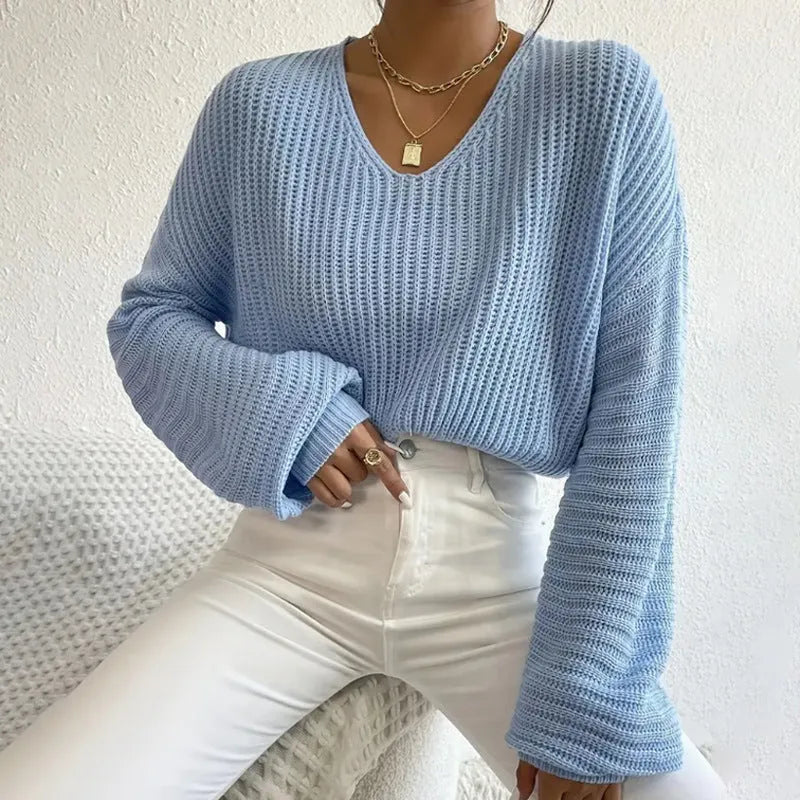 A woman wearing a solid colour long sleeve pullover in a loose, casual fit.