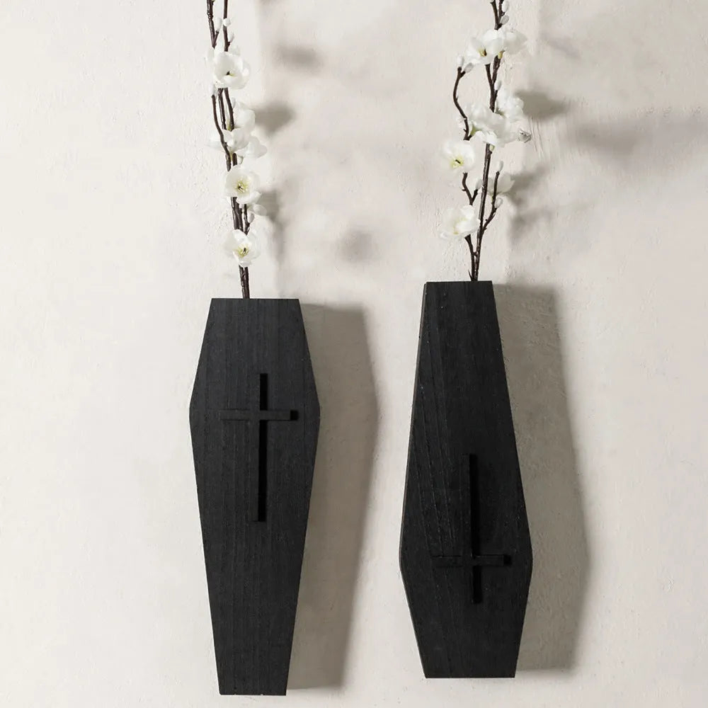 Black wooden cross-shaped wall shelf with a small ledge, measuring 27cm tall.