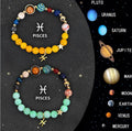 Two natural stone beaded bracelets with zodiac sign charms on a wooden surface.