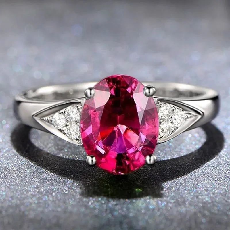 Close-up of a women's court style ring with a red zircon set in a heart-shaped pattern.