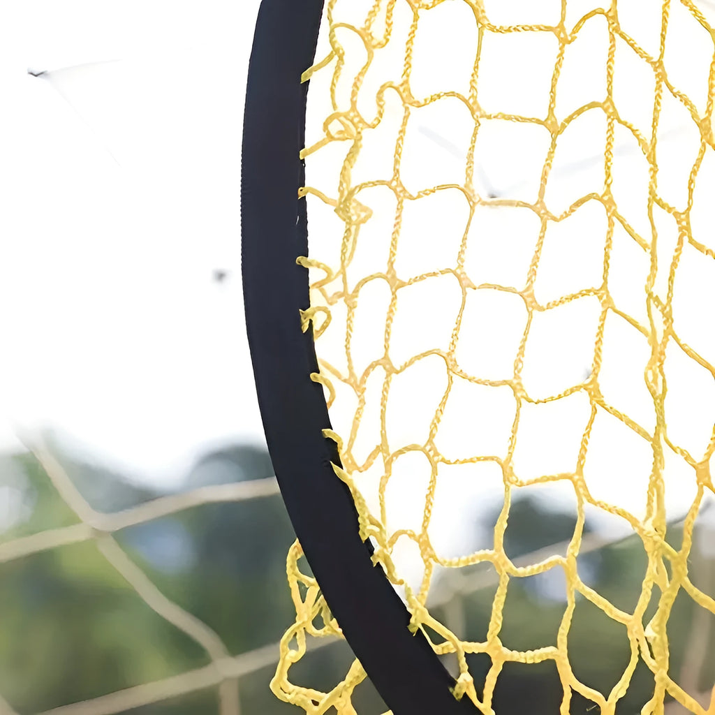 Portable black and yellow soccer training goal net set up on a grass field.